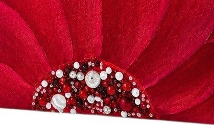 close up of Hand-painted rope handle beach tote featuring a bold red floral design with jeweled embellishments at the flower center, accented with natural jute trim and oversized white rope handles against a neutral background.