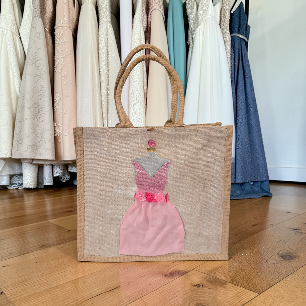 Hand-painted jute tote bag featuring a blush pink bridesmaid dress with floral details on a natural canvas background