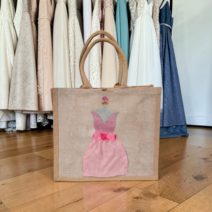 Hand-painted jute tote bag featuring a blush pink bridesmaid dress with floral details on a natural canvas background