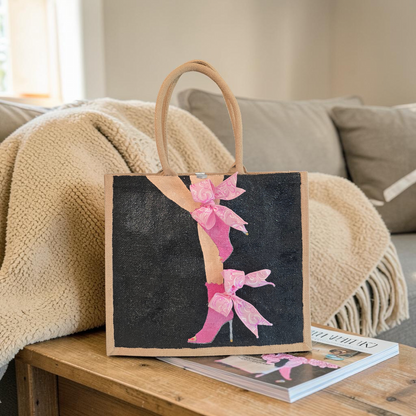 Hand-painted tote bag featuring a pink high heel with bows on a black background with dimensional ribbon accents