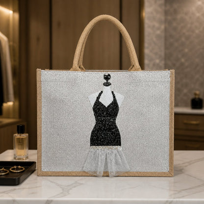 Hand-painted jute tote bag featuring a black glitter evening dress design on a mannequin form with sheer tulle accents, black embellishments, and natural burlap handles.