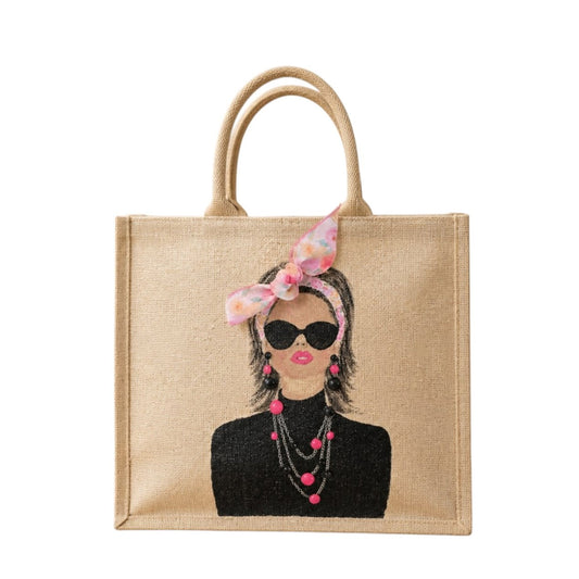 Hand-painted jute tote bag featuring a chic woman wearing oversized black sunglasses, layered pink and black jewelry, and a pink floral headscarf bow against a natural canvas background.