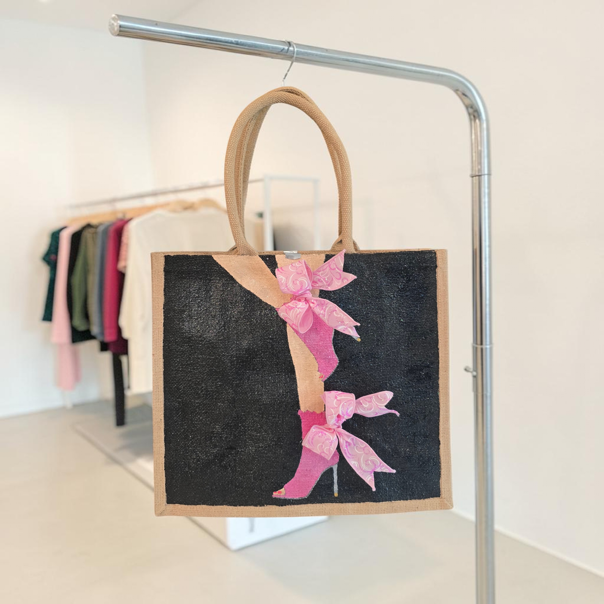 Hand-painted tote bag featuring a pink high heel with bows on a black background with dimensional ribbon accents