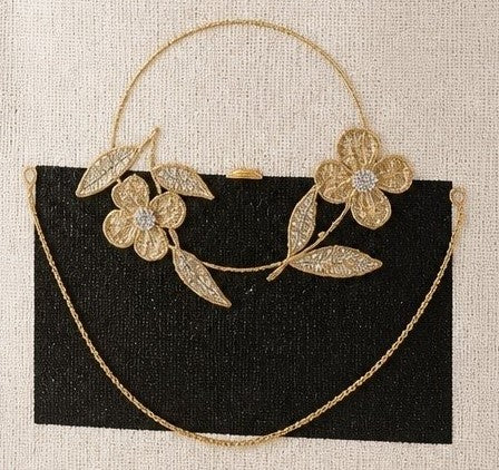 close up of Elegant hand-painted jute tote bag featuring a black rectangular purse design accented with delicate gold floral embellishments, leaves, and a draped gold chain detail. The structured tote has woven natural handles and a sophisticated neutral color palette with artisan-inspired styling.