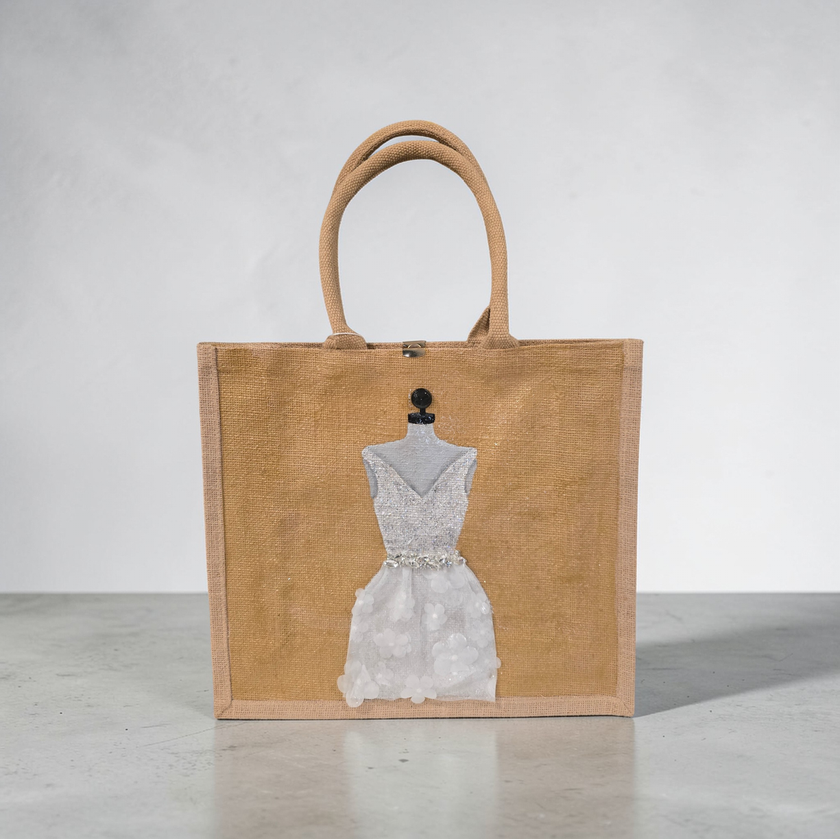 Hand-painted jute tote bag featuring an elegant white bridal dress with shimmering details on a natural canvas background