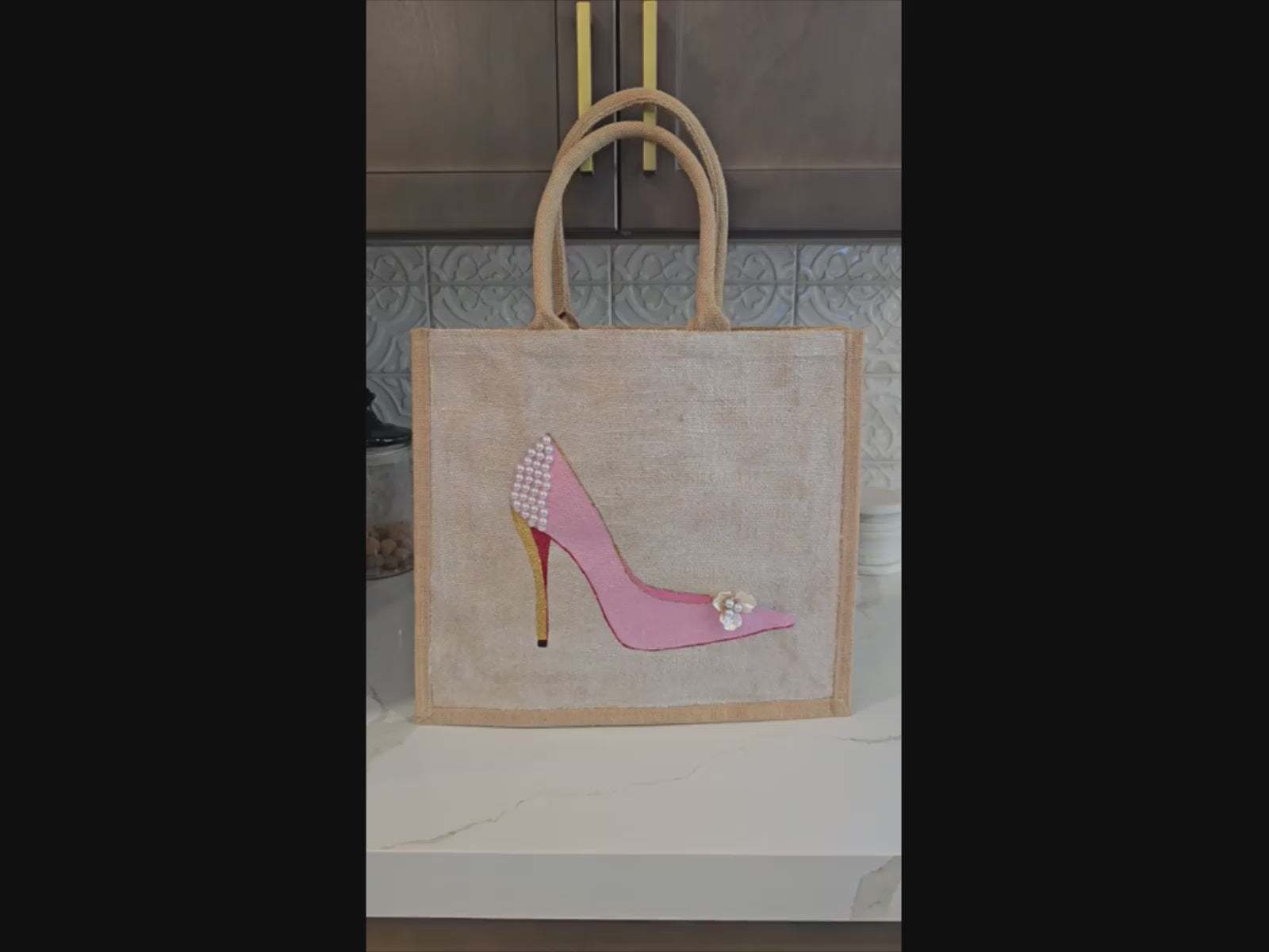 Pink Stiletto hand painted on jute tote bag embellished with jewels and pearls on an off white metallic background.