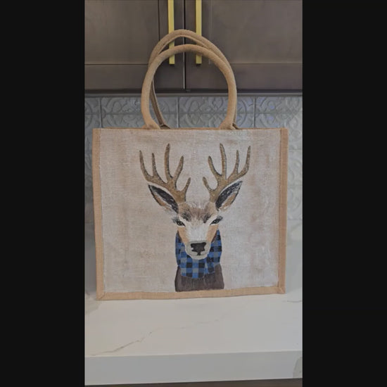 Hand-painted jute tote featuring a reindeer wearing a blue buffalo-plaid scarf.