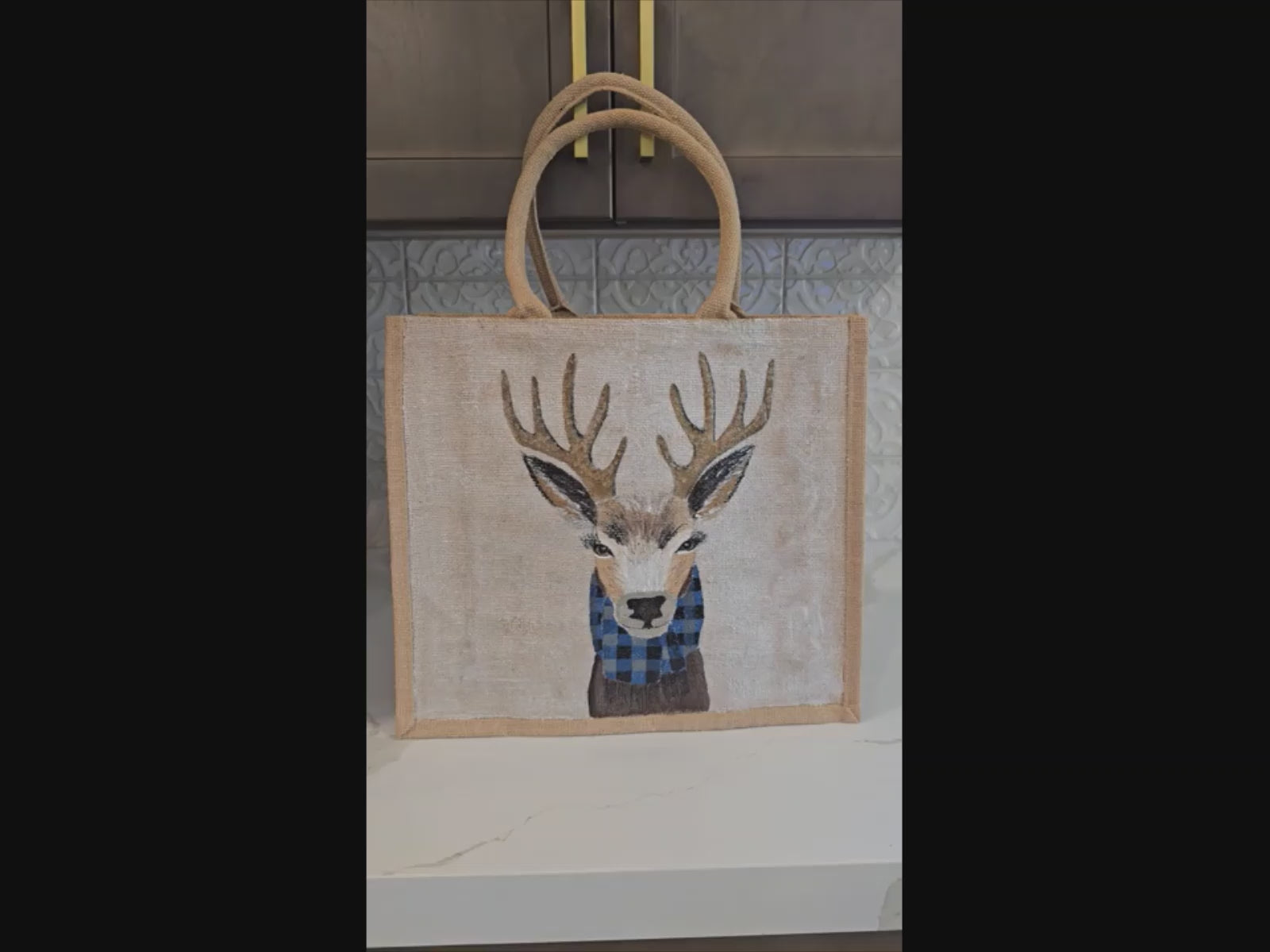 Hand-painted jute tote featuring a reindeer wearing a blue buffalo-plaid scarf.