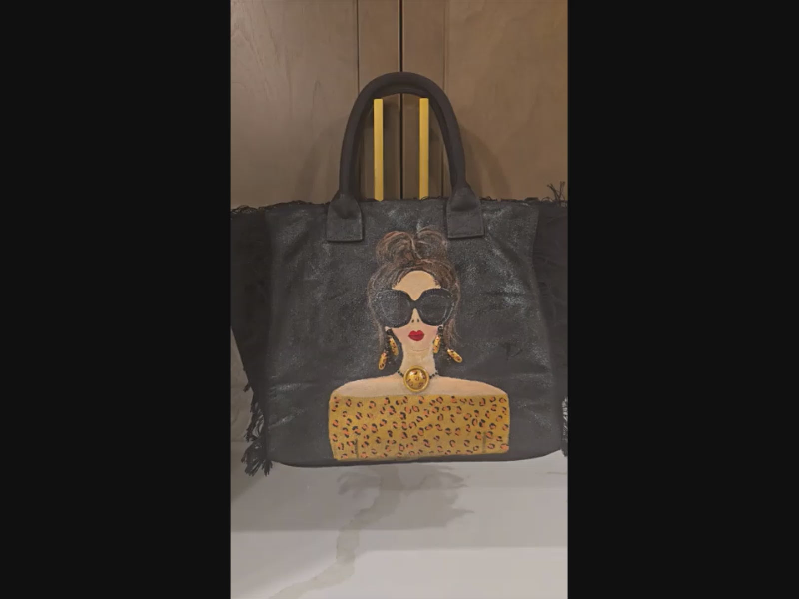 video of Hand-painted black fringed tote bag with glam sunglasses woman design and leopard print detail