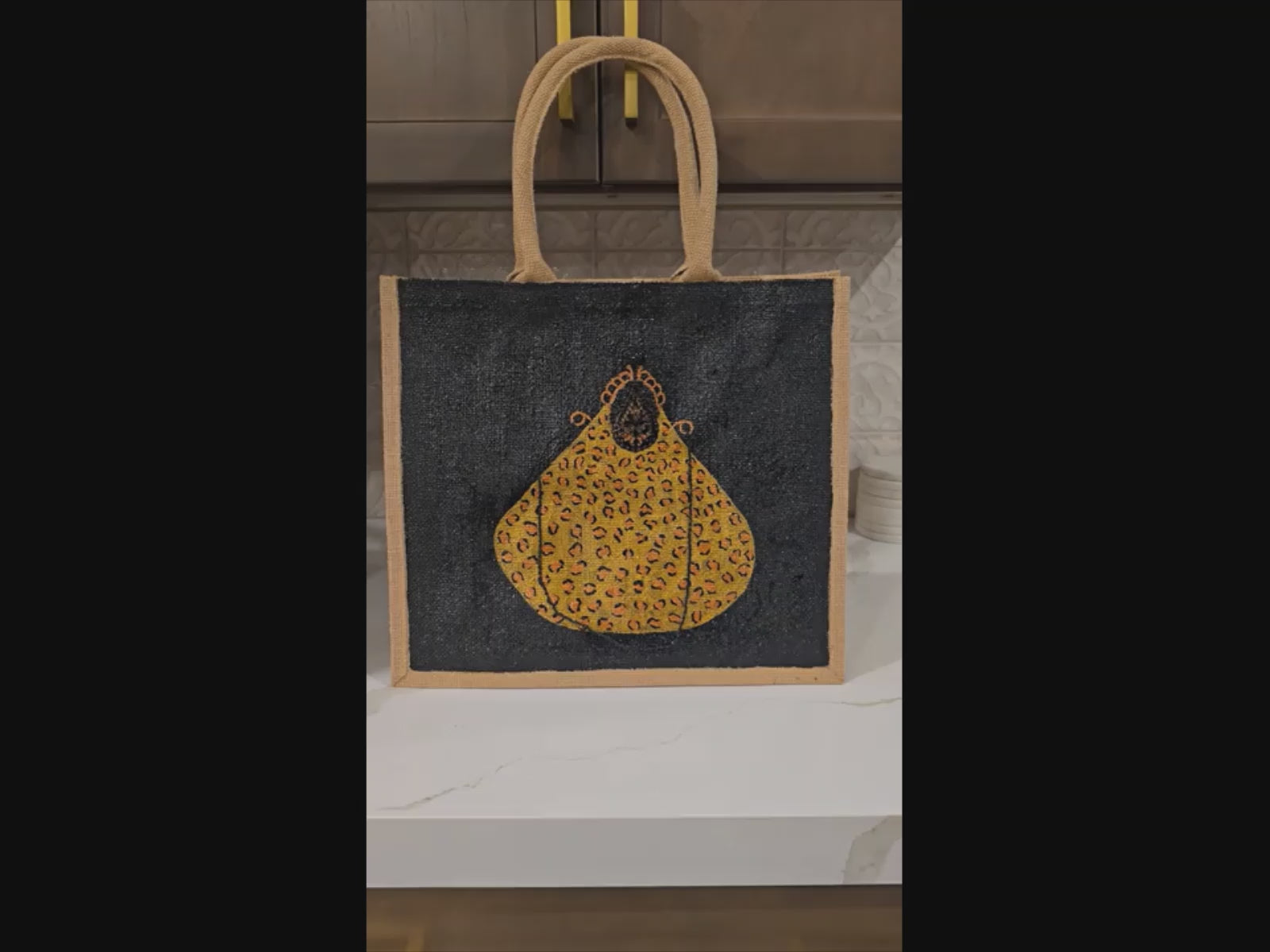 Video of Hand-painted black jute purse tote with gold leopard design and chain handles