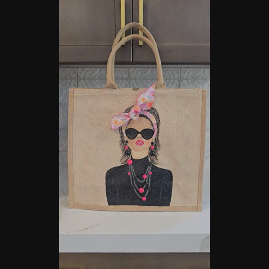 Video of Hand painted jute tote bag featuring a fashion portrait with sunglasses, pink bandana bow, and embellished statement jewelry