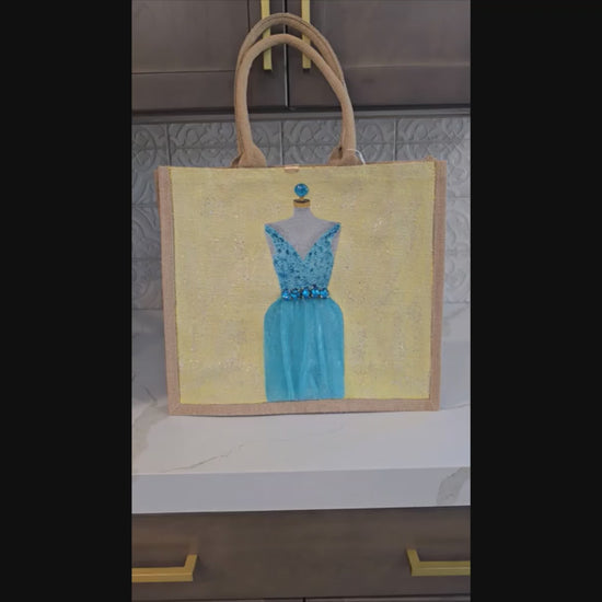 video of Hand-painted bridal tote bag featuring a white embellished wedding dress with textured floral skirt on a natural jute bag, perfect for bride gifts and wedding events.