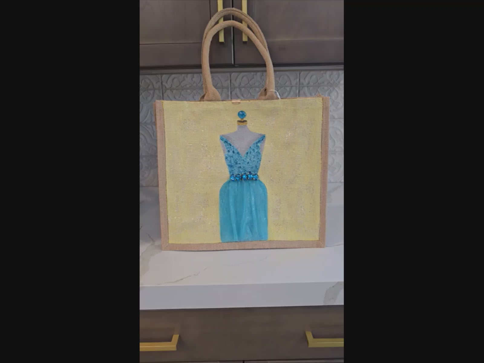 video of Hand-painted bridal tote bag featuring a white embellished wedding dress with textured floral skirt on a natural jute bag, perfect for bride gifts and wedding events.