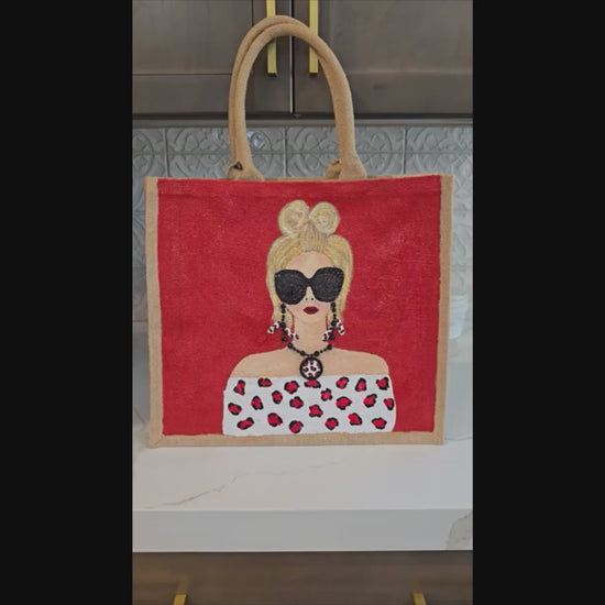 video of Hand-painted crimson red fashion tote bag with stylish woman illustration and leopard-inspired details on jute tote