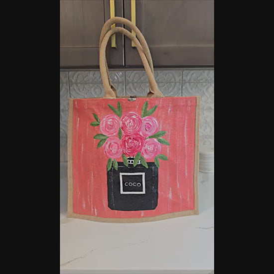 video of Hand painted floral jute tote bag with pink roses and black perfume bottle design