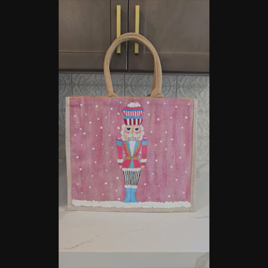 Hand-painted pink Nutcracker on a snowy background, on a jute tote bag.