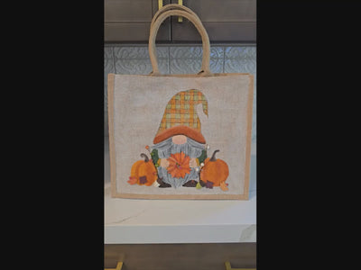 Hand-painted Fall Gnome tote bag with sunflowers, acorns, and berries on metallic jute background