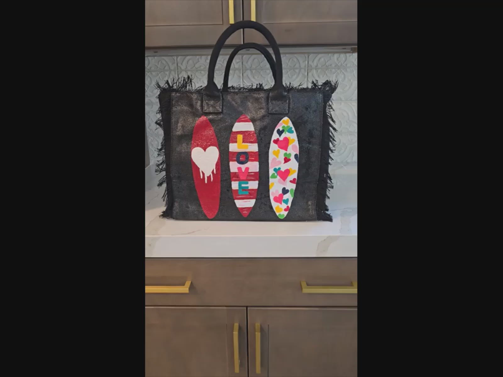 video of surfboard tote bag, fringed canvas beach tote, black surf tote, hand painted surfboard bag
