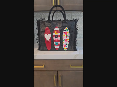 video of surfboard tote bag, fringed canvas beach tote, black surf tote, hand painted surfboard bag