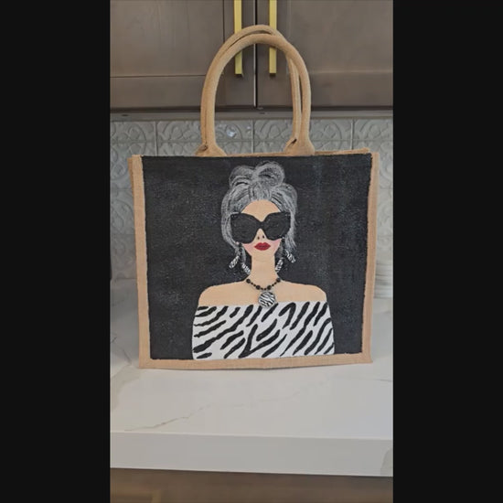 video of Hand-painted black and white fashion tote bag with zebra-inspired outfit and stylish woman illustration on jute tote