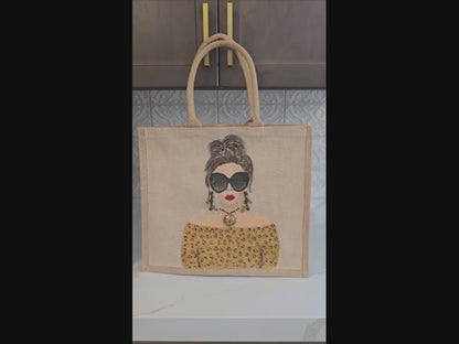 video of Hand-painted jute tote bag featuring a stylish woman with oversized black sunglasses, a leopard print off-the-shoulder top, statement earrings, and layered jewelry on a natural canvas background.