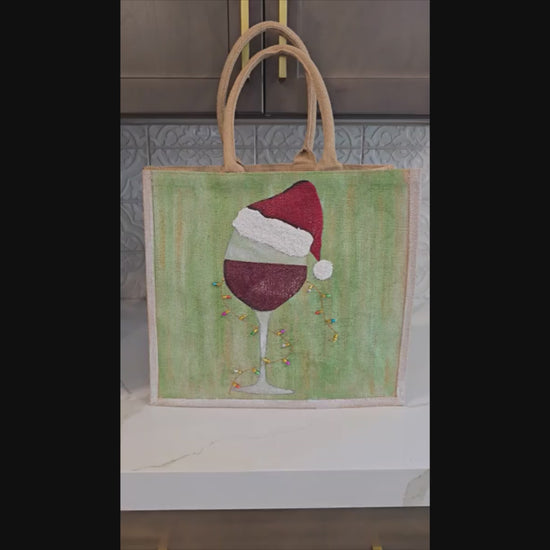 Hand-painted jute tote with a wine glass wearing a Santa hat and tiny holiday lights.
