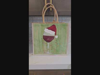 Hand-painted jute tote with a wine glass wearing a Santa hat and tiny holiday lights.