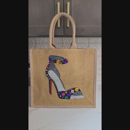 Video with close ups of Hand-painted black stiletto tote bag with gold jeweled accents on natural jute background