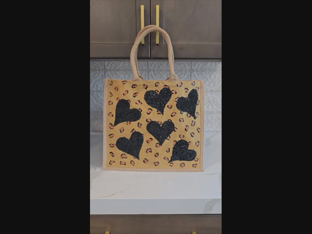 video of Hand Painted and embellished animal print with black beaded hearts tote bag by Dana's Uncommon Glass