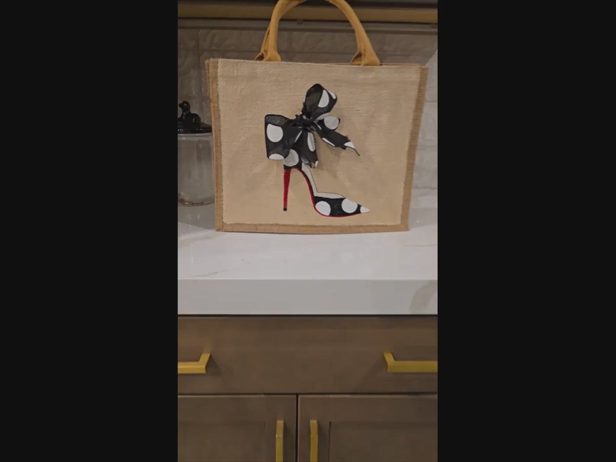 video of Off white jute tote bag with hand-painted black stilettos, white polka dots, red soles, and beaded accents.
