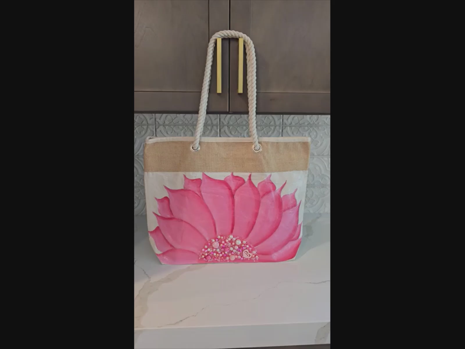 Video of Hand-painted rope handle tote bag featuring a bright pink sunflower with bead embellishments.