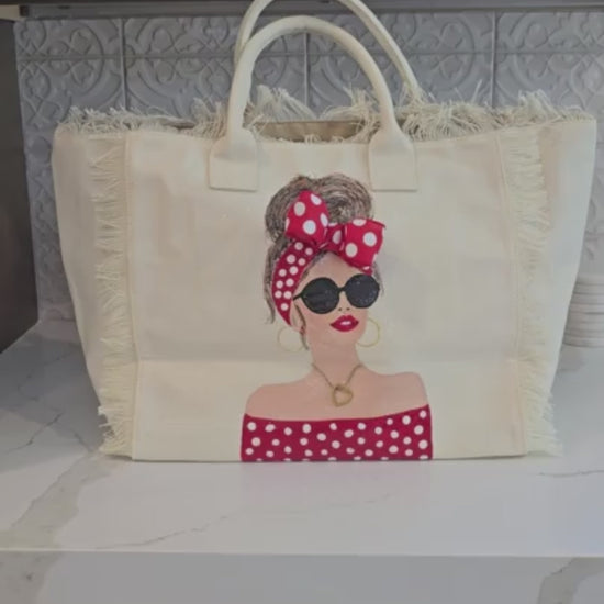 video of Scarlet Muse hand-painted fringed canvas tote with brunette woman in red and white polka dots