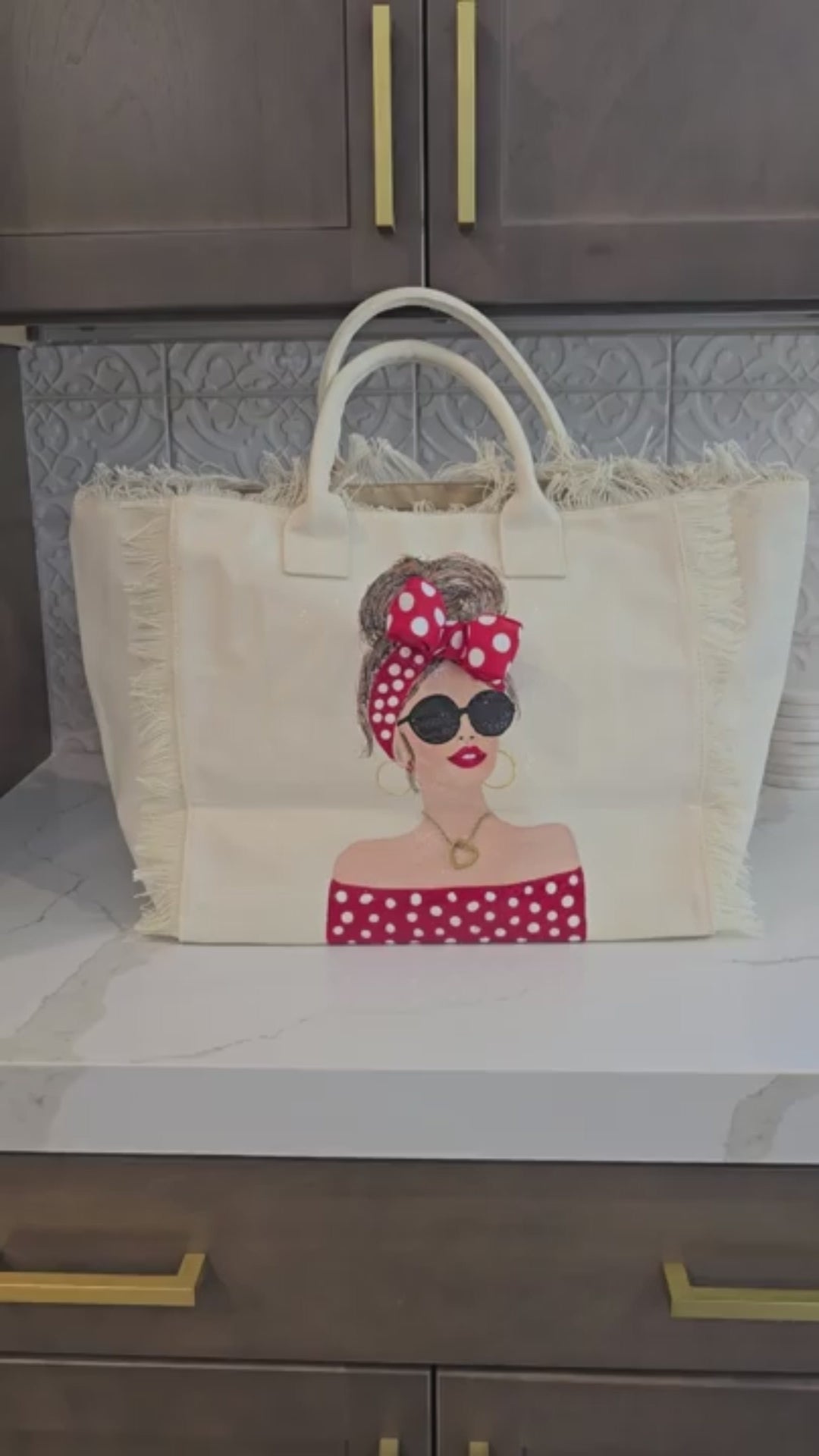 video of Scarlet Muse hand-painted fringed canvas tote with brunette woman in red and white polka dots