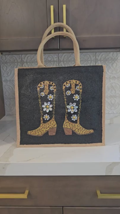 close up video of  Hand-painted black and gold cowboy boot tote bag with jeweled flowers on a black background