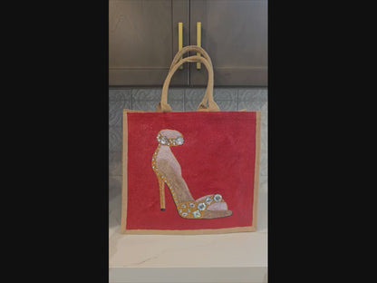 Video of Hand-painted gold stiletto tote bag with jeweled accents on natural jute background with close ups