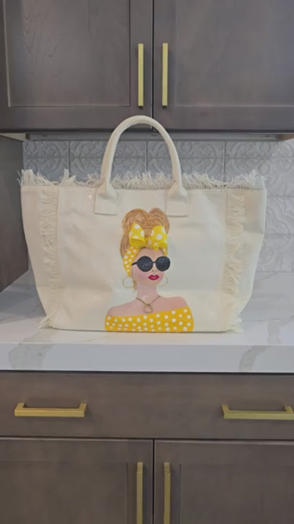 close up video of Sunshine Muse hand-painted fringed canvas tote with blonde woman in yellow polka dots and sunglasses