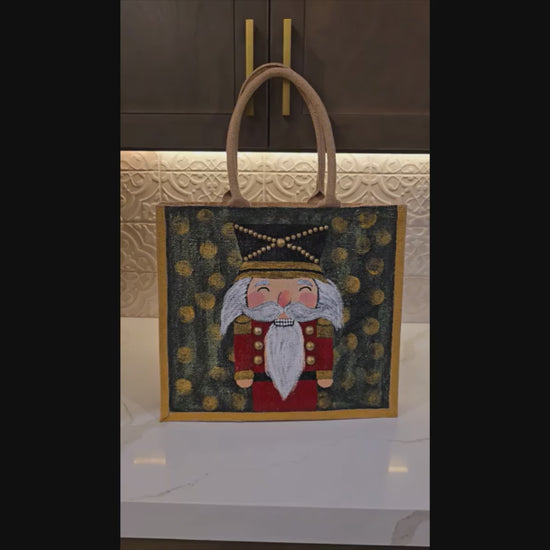 Hand-painted classic nutcracker tote with golden bokeh background, 
Festive nutcracker artwork on artisan jute bag, Traditional holiday nutcracker on lined jute tote
