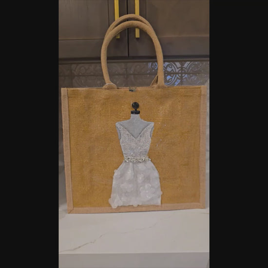 Hand-painted jute tote bag featuring an elegant white bridal dress with shimmering details on a natural canvas background
