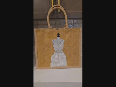 video of Hand-painted jute tote bag featuring an elegant white bridal dress with shimmering details on a natural canvas background