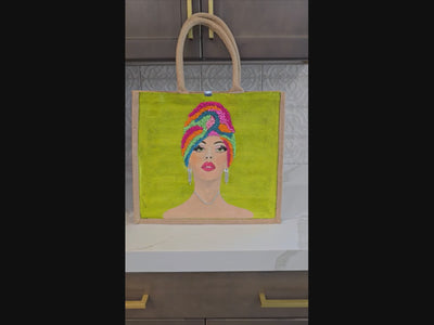 Video of Hand-painted Vivid Muse tote bag featuring a stylish woman with a colorful beaded headwrap, bold makeup, and sparkling jewelry on a vibrant green background, a unique artistic fashion statement bag.