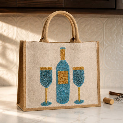 Hand-painted jute tote bag featuring a blue wine bottle and two wine glasses in textured blue and gold detailing on a natural canvas background with braided handles.